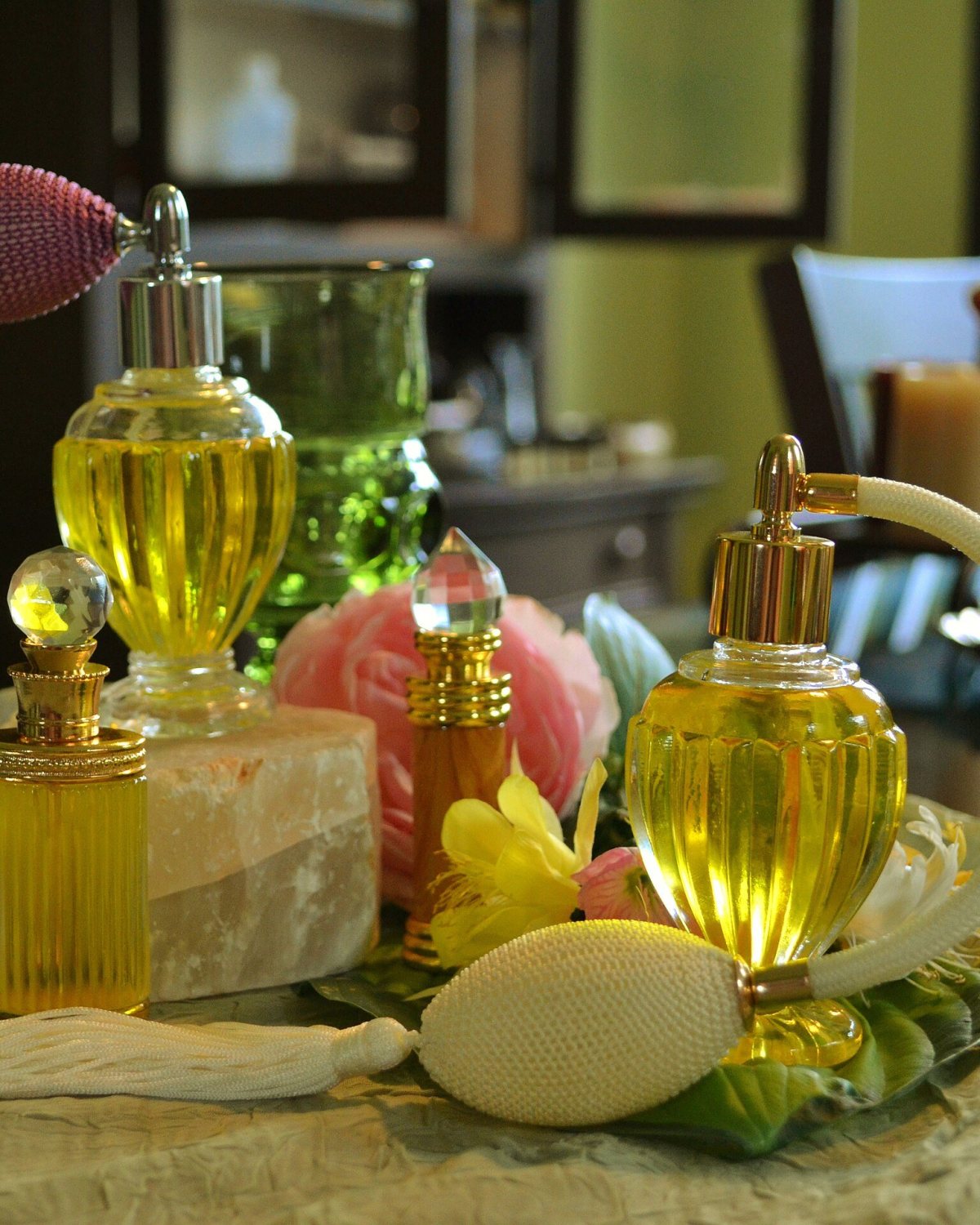 قوارير عطر ذهبية بمضخات رذاذ بين الورود