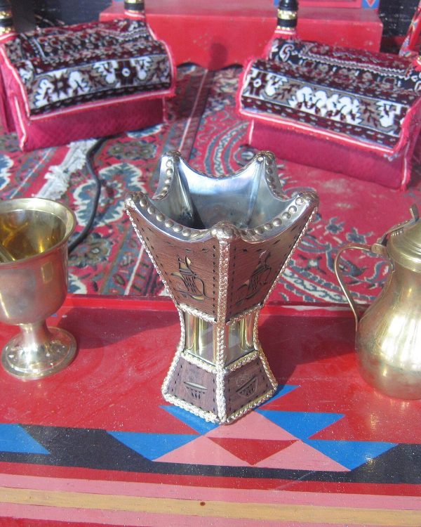 مبخرة ودلّة قهوة وهاون نحاسي على سجادة حمراء